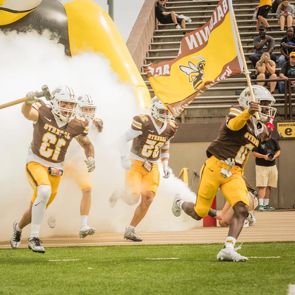 BW football players rush the field during pre-game introductions